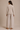 a woman wearing a raw edge blazer in sand and matching pleated pants