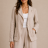 a woman wearing a raw edge blazer in sand and matching pleated pants