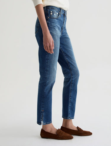 A women wearing blue jeans from full side profile and brown shoes on a white background