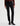 A woman wearing slim straight jeans in black with black boots and a maroon long sleeve tee on a white background.