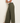 Person wearing olive green wide-leg pants against a plain background