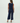 Woman wearing a navy blue sleeveless top and wide-leg pants on a white background