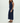 Woman wearing a navy blue sleeveless jumpsuit on a white background