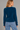a woman wearing a brushed yarn crewneck sweater in a deep blue and blue jeans