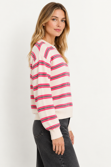 A woman wearing a cashmere beige pink-striped sweater on a white background.