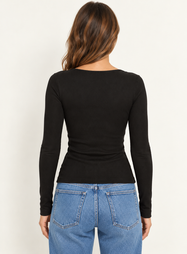 A woman wearing a black long sleeve top with blue jeans on a white background