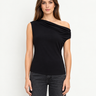 Delilah black drape top, front view showing asymmetrical off-the-shoulder neckline with dark jeans