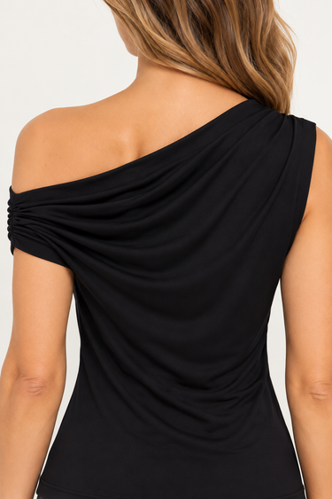 A close up on the back drape detailing of the a black off shoulder top on a white background.