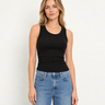 a woman wearing a black shine crop tank with ruched side detailing on a white background 