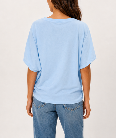 Person wearing a light blue t-shirt and jeans on a plain background