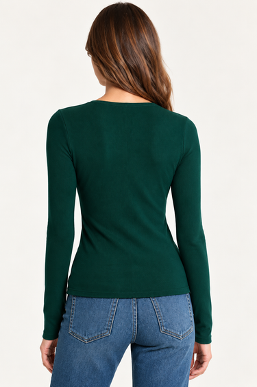 A woman viewed from the back wearing a fitted long-sleeve dark green top and blue jeans against a plain light background.