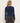 A woman facing backwards wearing a cropped navy blue long sleeve tee and black jeans on a white background.