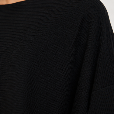 Close-up of a black ribbed knit top showing the textured fabric and shoulder area.