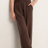 A woman wearing brown knit pants on a white  background