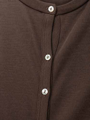 Close-up of a dark brown ribbed knit top with a short button placket and white buttons.