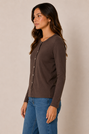 A woman wearing a dark brown long-sleeve button-front cardigan and blue jeans, standing against a plain beige studio background.
