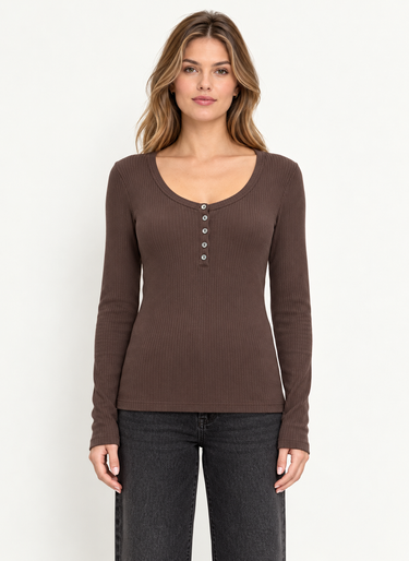 A woman standing forward wearing a scoop neck ribbed henley long sleeve tee in brown with black jeans on a white background.