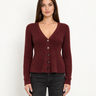 a woman wearing a burgundy ribbed v-neck cardigan and blue jeans on a white background.