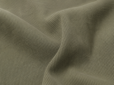 A close-up of olive green ribbed fabric with soft folds and a fine vertical corduroy-like texture.