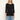 A woman wearing a black three-quarter sleeve crewneck top and blue jeans, standing against a plain off-white background.