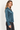 Everly Petrol satin long sleeve collared top, angled view showing wide cuffs and draped silhouette