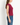 A woman shown in side profile wearing a sleeveless, ribbed knit top in deep burgundy and blue jeans, against a plain white studio background.