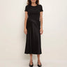 a woman wearing a black tee and a black bias midi skirt on a white background.