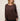 A woman wearing a dark brown long-sleeve top with a relaxed fit and a crew neckline, shown from the shoulders down against a plain light background.