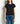 Person wearing a black t-shirt and blue jeans against a plain background