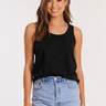 Woman wearing a black tank top and blue denim shorts on a white background