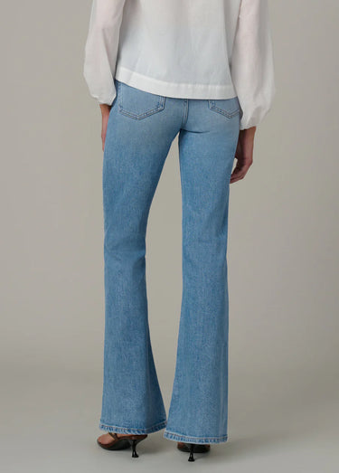 A woman wearing light blue high rise flare jeans