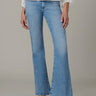 Person wearing light blue flared jeans on a neutral background