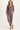 Woman wearing a brown jacket and pants on a white background