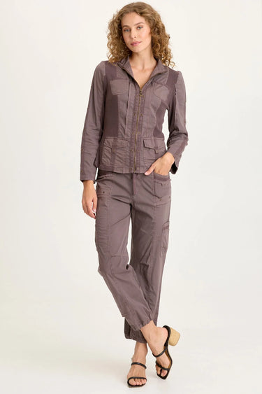 Woman wearing a brown jacket and pants on a white background