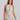 Woman wearing a patterned halter neck dress on a plain background