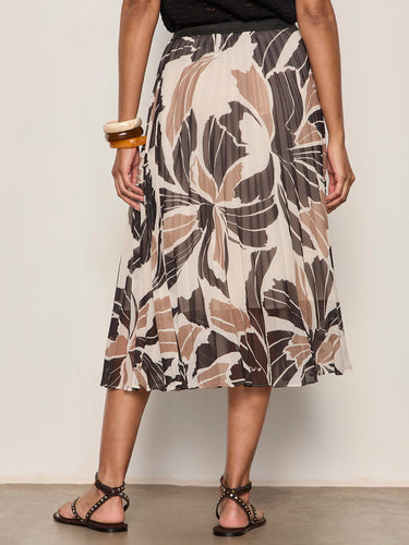 Person wearing a patterned skirt with a neutral background