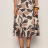 Person wearing a patterned skirt with a plain background