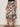 Person wearing a patterned skirt with a plain background
