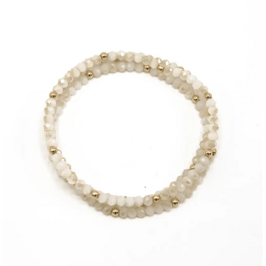 White beaded bracelet with gold filled beaded accents on a white background