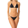 a woman wearing a black triangle bikini top and bikini bottoms with gold accents on a white background 