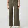 A model wearing olive green wide-leg cropped pants with a cream drawstring waist, paired with a white top and white sneakers, against a light gray studio background.