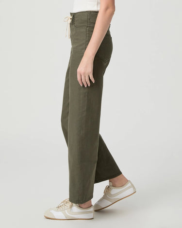 A person wearing olive green wide-leg cropped pants with a cream drawstring waist, paired with white sneakers, shown from the waist down against a light gray studio background.