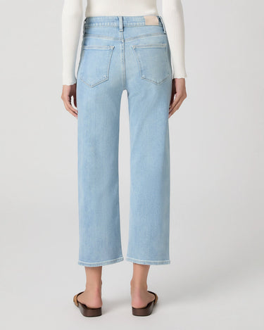 Light blue cropped straight jeans worn by a person on a white background