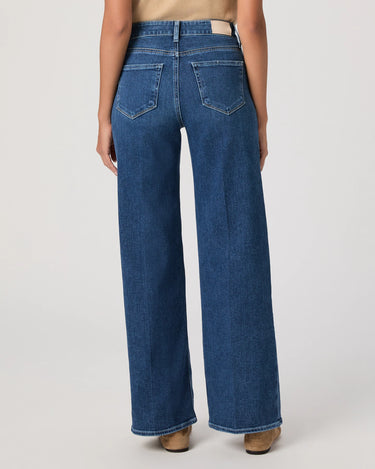 Person wearing blue wide-leg jeans on a white background