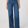 Person wearing blue jeans on a plain background
