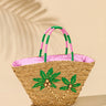 Woven basket with pink interior and green palm tree designs on a beige background