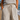 Person wearing a striped shirt and pants with a blurred beach background