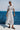 Woman in a striped dress standing by the ocean