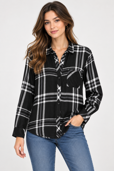 a woman wearing a black and ivory plaid collared shirt and blue jeans on a white background.