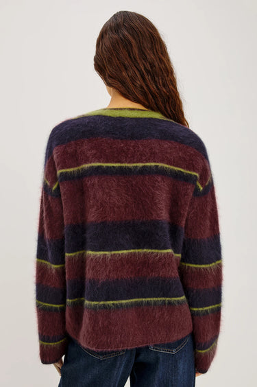 A woman wearing a burgundy, navy and green stripe brushed wool crew neck sweater and dark blue denim jeans on a white background 